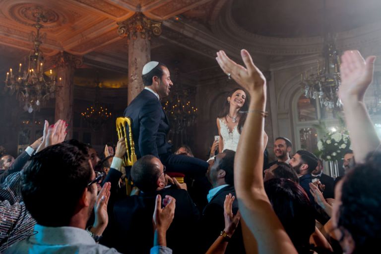 Photographe Mariage Juif Cannes.Les mariés portés sur des chaises au Carlton de Cannes
