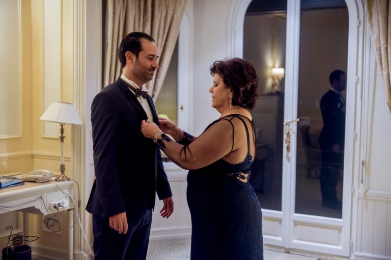 Photographe Mariage Juif Cannes, Nice, Monaco. La maman habille son fils dans une suite du Carlton