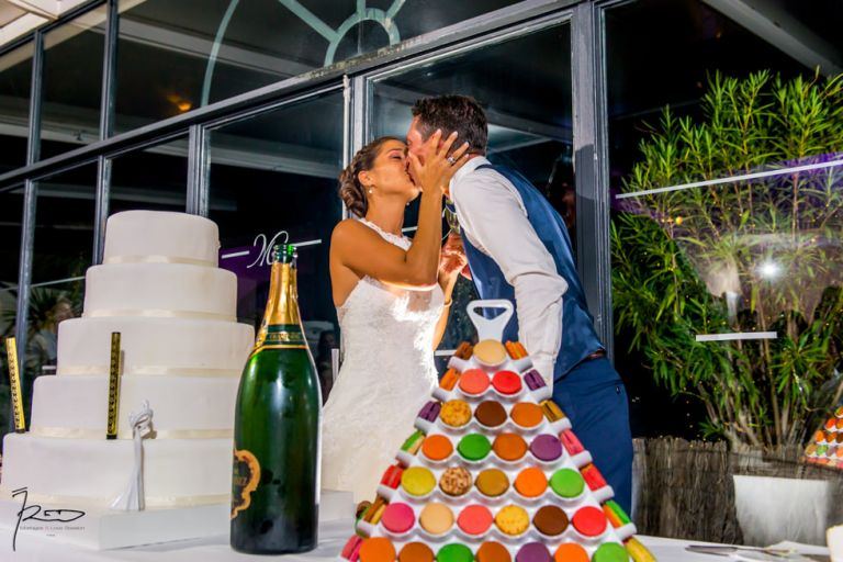 Photographe mariage Var. photographe mariage Hyères. La mariée embrasse son époux pendant la coupe du gâteau