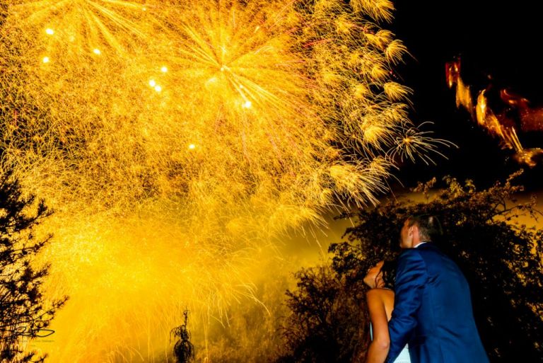 Superbe feu d'artifice jaune en pose lente. Les mariés s'enlace devant le feux