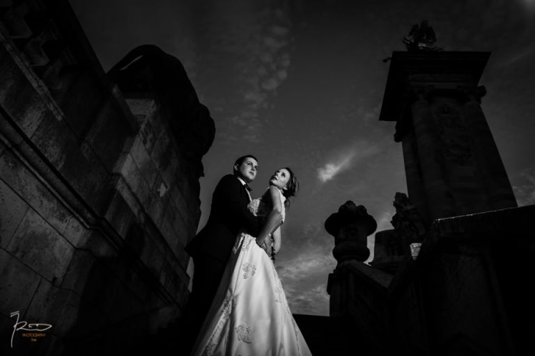 Dans les escaliers du Pont Alexandre III à Paris un couple de mariés en costumes de mariage.