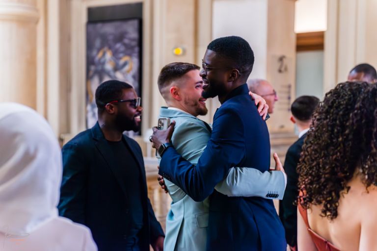 Amis du marié le serrant dans leurs bras après la cérémonie à la mairie du 10e Paris