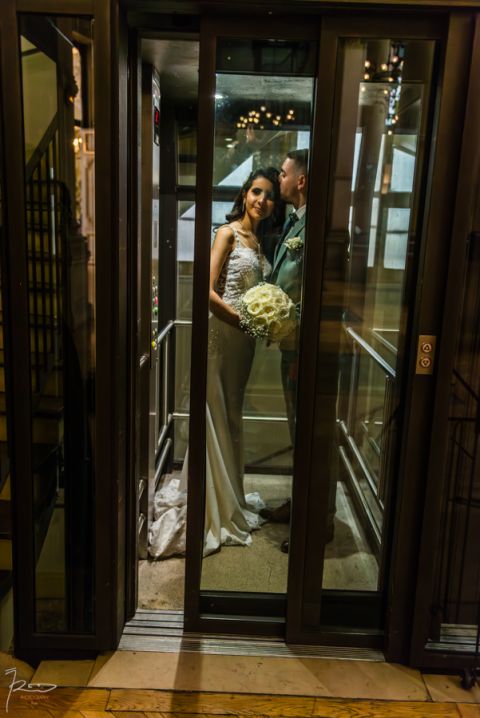 Porte vitrée se refermant à la mairie du 10e Paris avec reflets de lustres