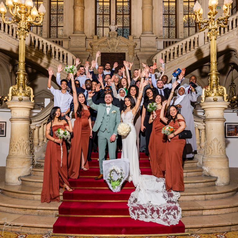 Invités célébrant les mariés en bas de l'escalier de la mairie du 10e Paris