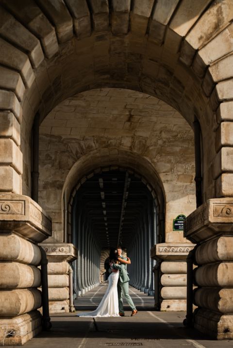 Mariés marocains sous les arcades du pont Bir-Hakeim à Paris, photographiés en grand angle avec effet de perspective.