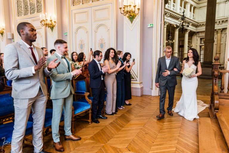 Mariée marocaine avec son père ému entrant dans la salle des mariages à Paris