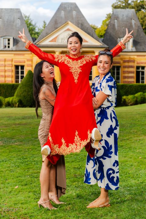 Photographe mariage vietnamien. photo de famille. La mariée vietnamienne est portée par d'autre femmes