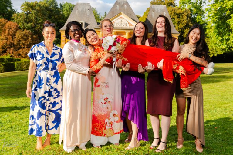 Photographe mariage vietnamien. photo de famille. La mariée vietnamienne est portée par d'autre femmes
