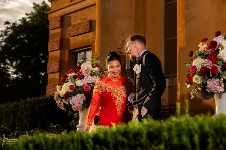 Sur le péron du Mariage vietnamien Paris. Domaine nos deux mariés rient de bonheur